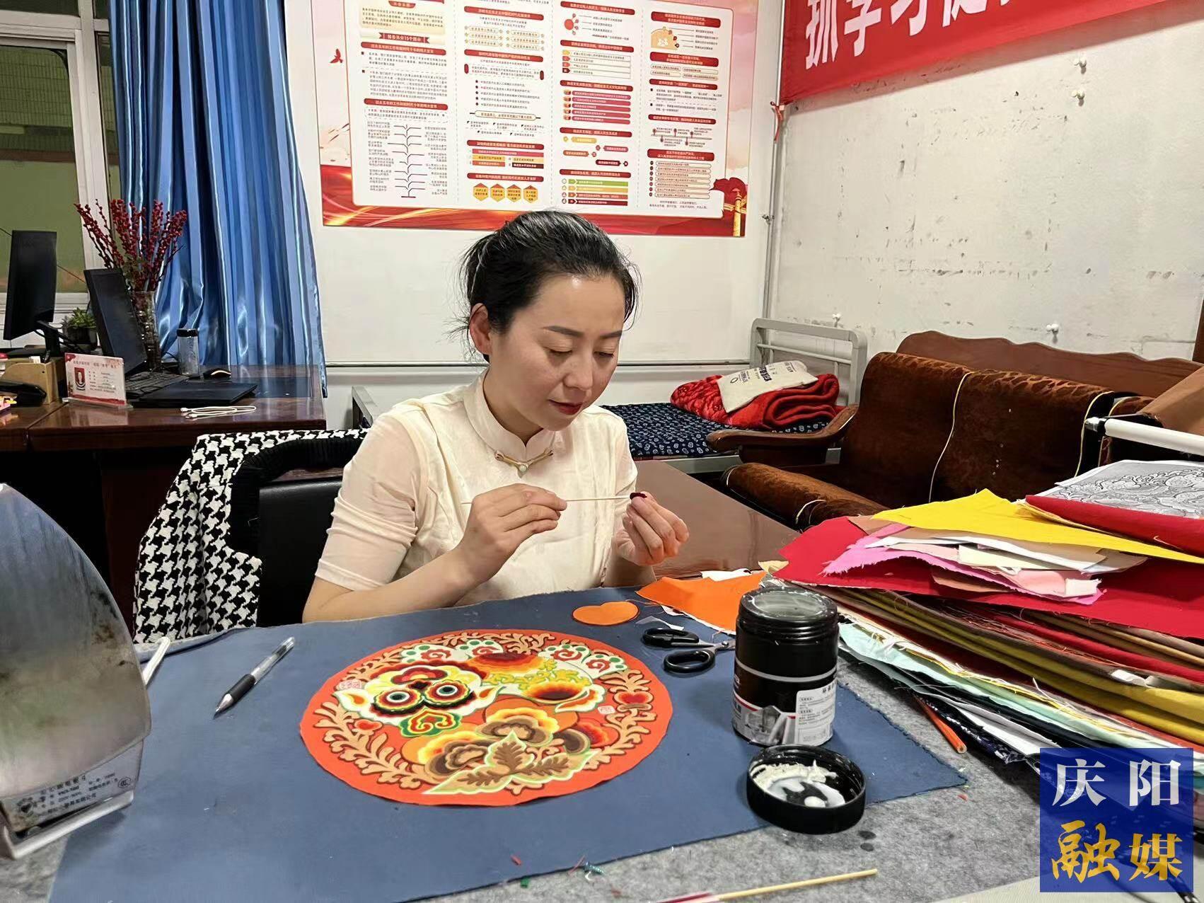 李慶英正在創(chuàng)作布貼畫作品。